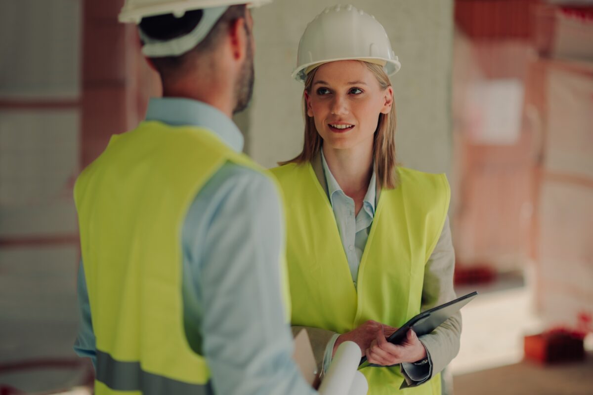 Engineers discussing building plans on construction site