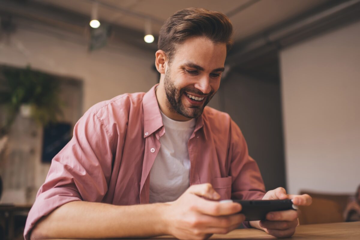 Un hipster joyeux prend le temps de jouer à la 3D virtuelle à l'aide du joystick de la console de nintendo en attendant.